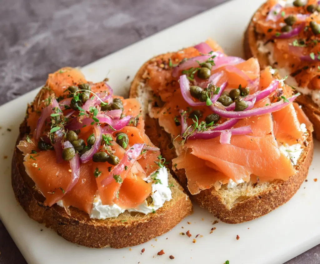 Close-up of delicious smoked salmon bruschetta topped with fresh herbs and a lemon wedge, perfect appetizer for parties.