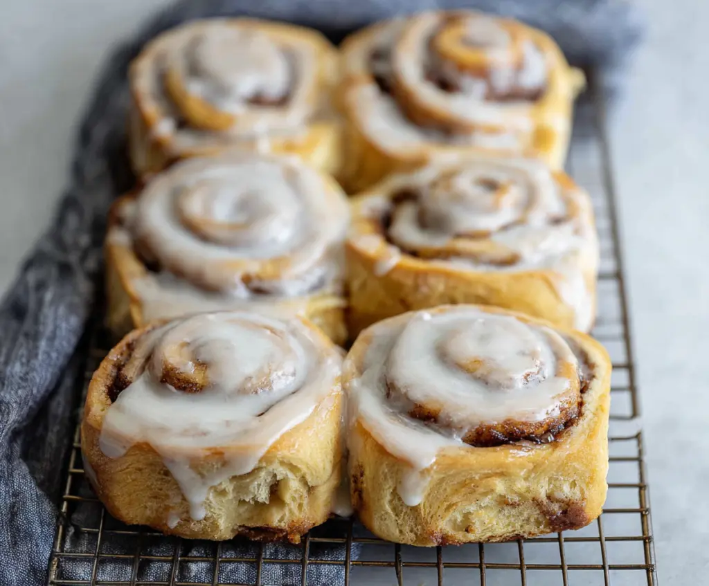 Delicious 30-minute sourdough discard cinnamon rolls fresh out of the oven, showcasing their golden-brown, flaky layers topped with cinnamon sugar icing.